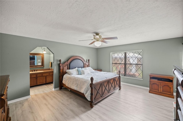 bedroom featuring a textured ceiling, ceiling fan, sink, and light hardwood / wood-style flooring