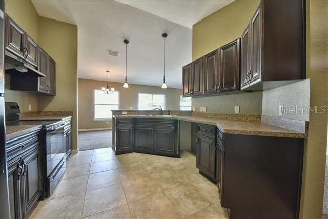 kitchen featuring kitchen peninsula, pendant lighting, light tile floors, electric range oven, and an inviting chandelier