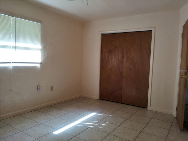 2008 NW 14th St, Ocala, FL 34475 - unfurnished bedroom with light tile patterned floors, a closet, and baseboards