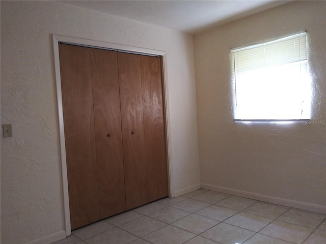 2008 NW 14th St, Ocala, FL 34475 - unfurnished bedroom featuring a closet, baseboards, and light tile patterned floors