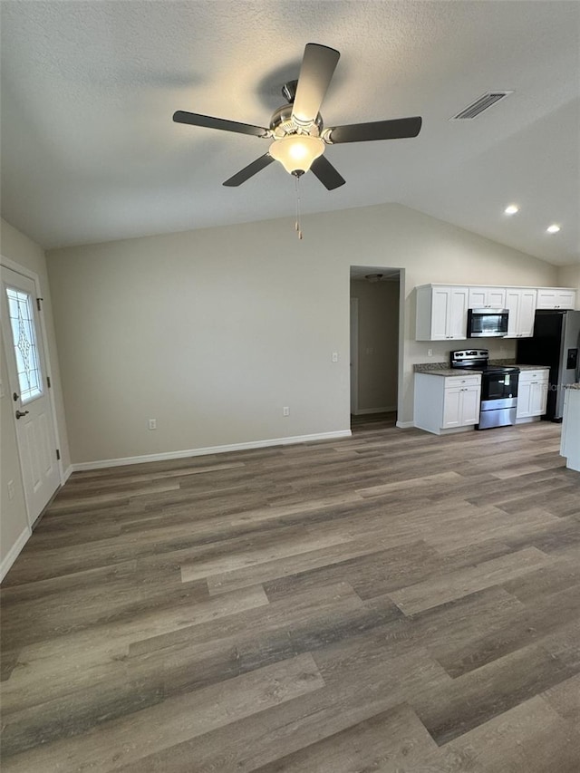 unfurnished living room featuring ceiling fan, wood-type flooring, vaulted ceiling, and a textured ceiling