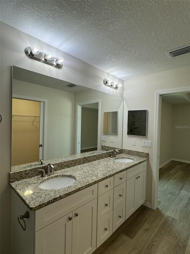 bathroom with vanity, hardwood / wood-style floors, and a textured ceiling