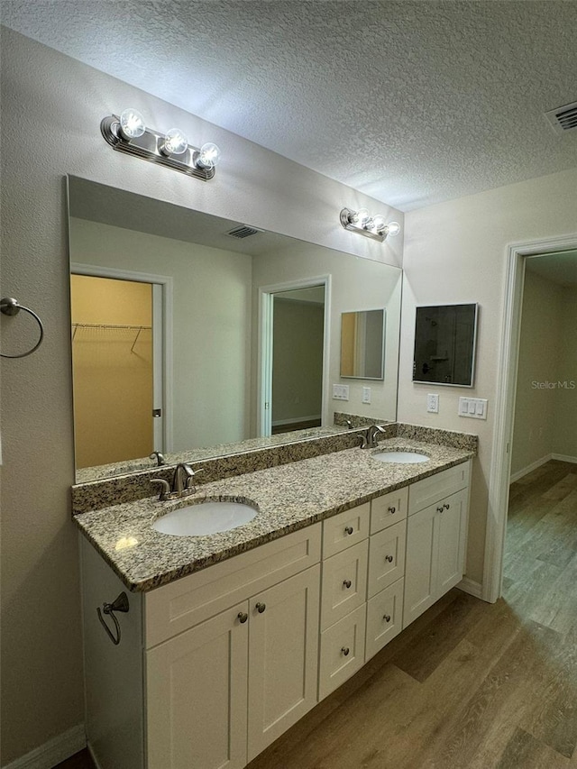 bathroom with vanity, hardwood / wood-style floors, and a textured ceiling