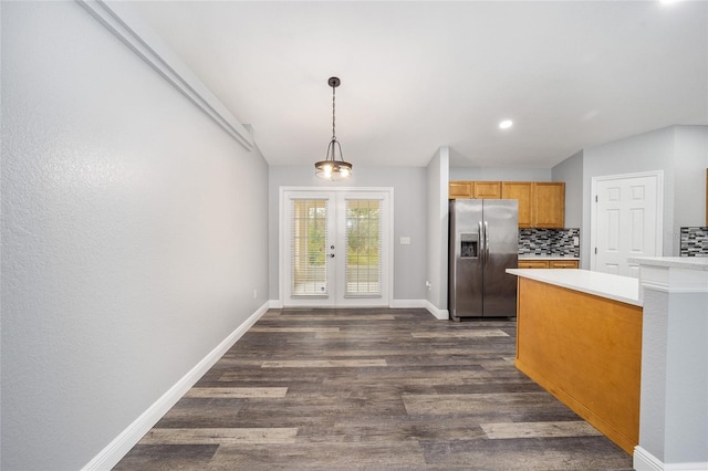 kitchen featuring french doors, hanging light fixtures, dark hardwood / wood-style flooring, backsplash, and stainless steel fridge