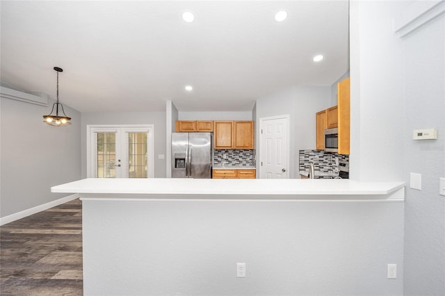 kitchen featuring backsplash, kitchen peninsula, stainless steel appliances, and decorative light fixtures