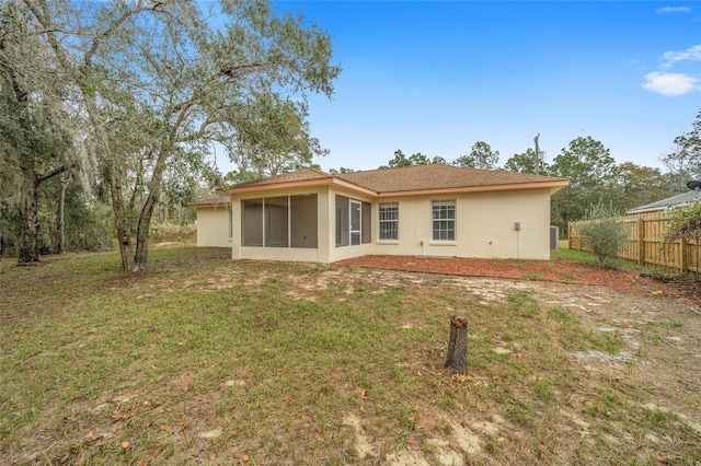 back of property with a yard and a sunroom