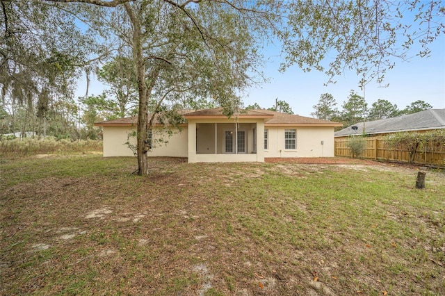 rear view of property featuring a lawn