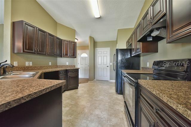 kitchen with sink, black appliances, and dark brown cabinets