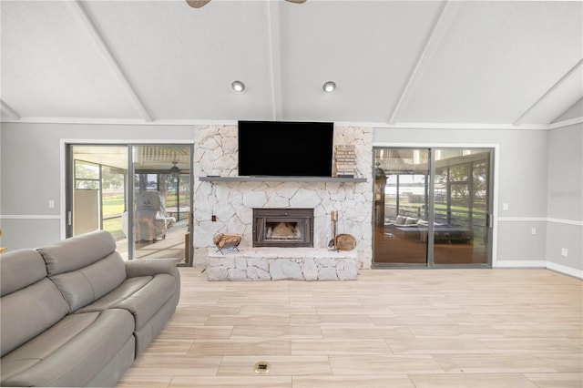 living room featuring light wood-type flooring, a stone fireplace, and lofted ceiling with beams