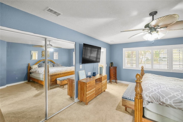 bedroom with light carpet, a closet, ceiling fan, and multiple windows