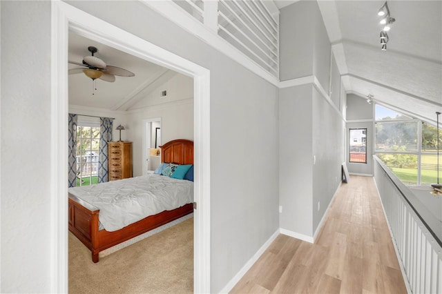 bedroom featuring ceiling fan, light hardwood / wood-style flooring, and vaulted ceiling