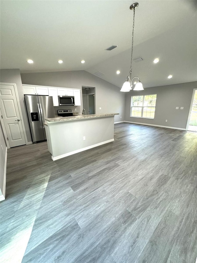 kitchen featuring stainless steel appliances, white cabinetry, pendant lighting, and an island with sink