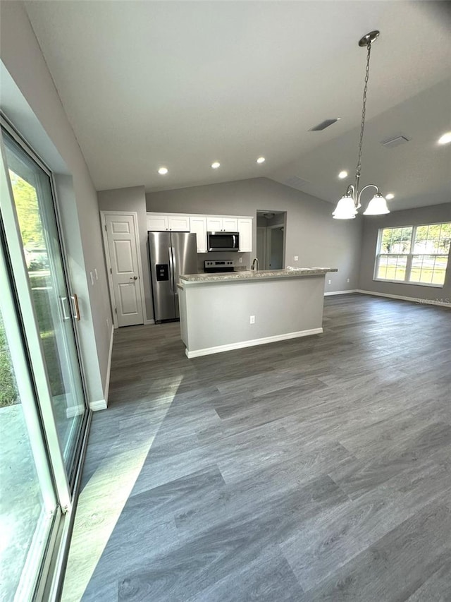 kitchen with appliances with stainless steel finishes, a notable chandelier, white cabinets, decorative light fixtures, and vaulted ceiling