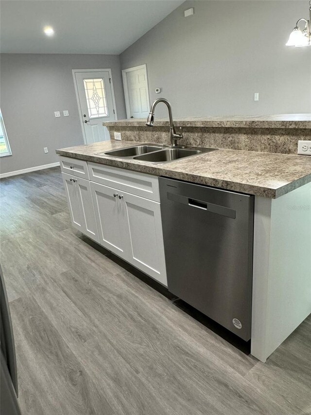 kitchen with decorative light fixtures, white cabinetry, dishwasher, sink, and an island with sink