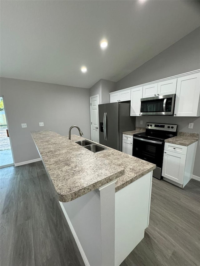 kitchen with sink, white cabinets, dark hardwood / wood-style flooring, a kitchen island with sink, and stainless steel appliances