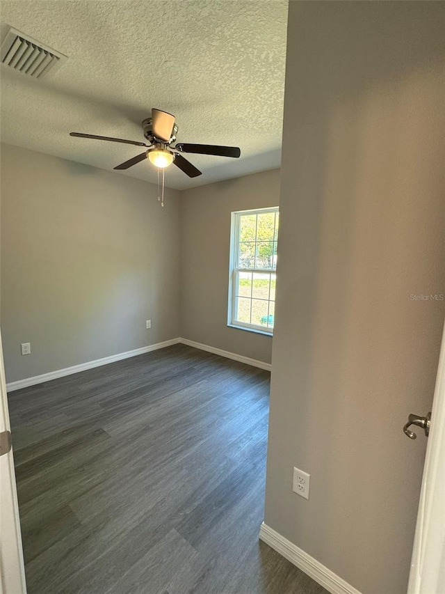 unfurnished room with ceiling fan, dark hardwood / wood-style flooring, and a textured ceiling