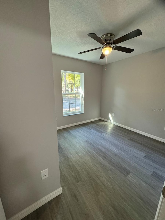 unfurnished room with ceiling fan, dark hardwood / wood-style flooring, and a textured ceiling