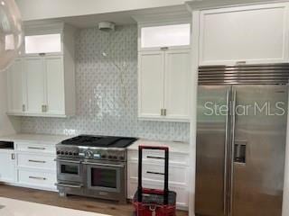 kitchen featuring high end appliances and white cabinetry