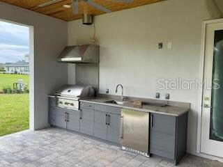 interior space featuring wood ceiling, stainless steel appliances, sink, and extractor fan