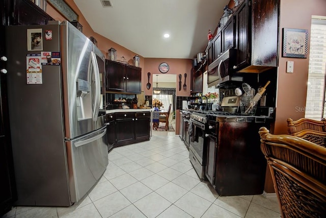 kitchen with dark brown cabinets, light tile patterned floors, and stainless steel appliances