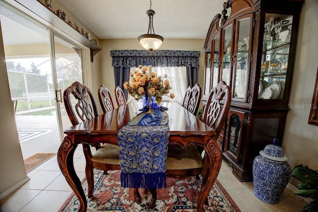 tiled dining area with a textured ceiling