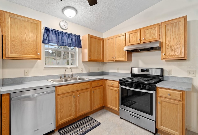 kitchen featuring lofted ceiling, sink, ceiling fan, stainless steel appliances, and a textured ceiling