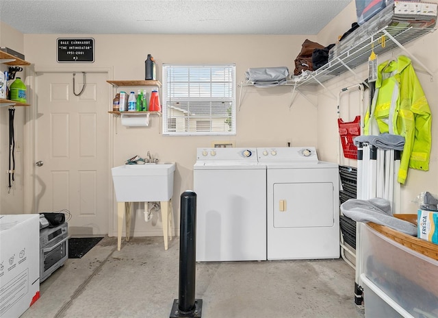 washroom with washing machine and dryer and a textured ceiling