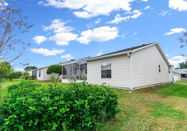 back of property with a lanai and a lawn