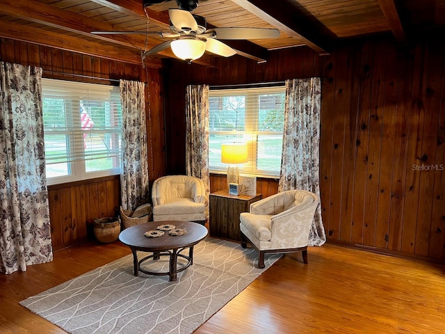 sitting room featuring wooden walls, ceiling fan, wooden ceiling, and light hardwood / wood-style flooring