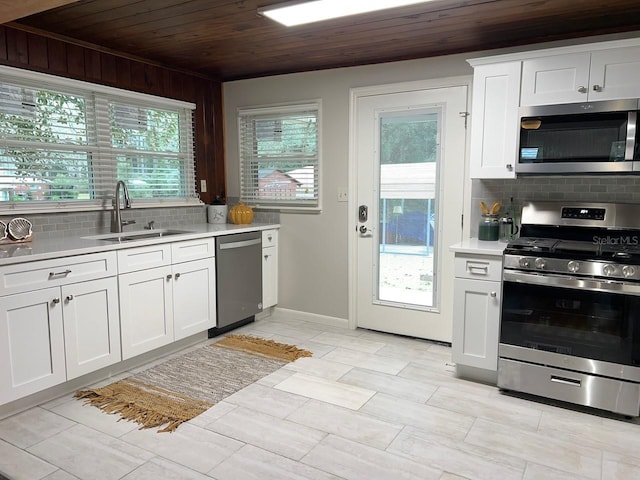 kitchen with white cabinets, wooden ceiling, stainless steel appliances, and tasteful backsplash