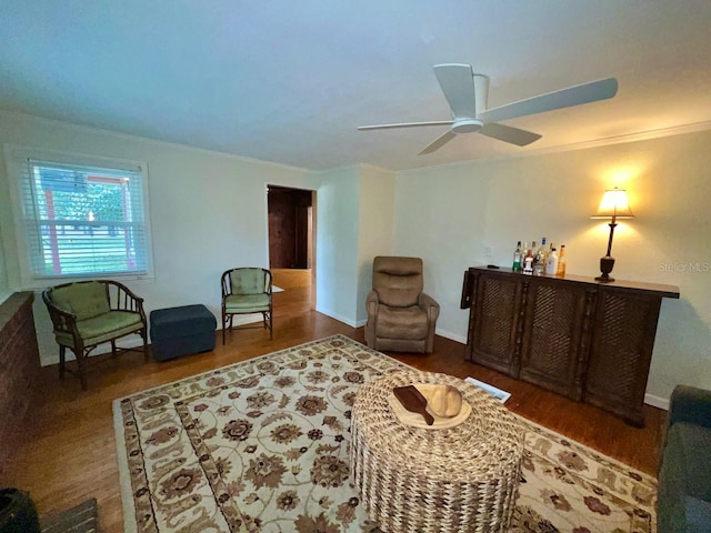 living room with crown molding, ceiling fan, and dark wood-type flooring