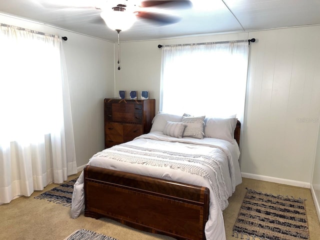 bedroom with light carpet, ceiling fan, and multiple windows