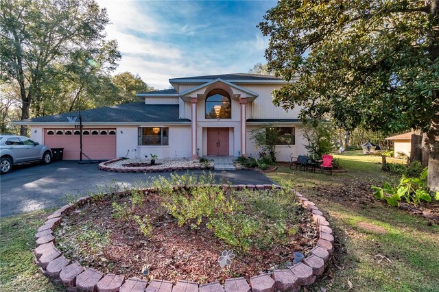 view of front of home with a garage and a front lawn