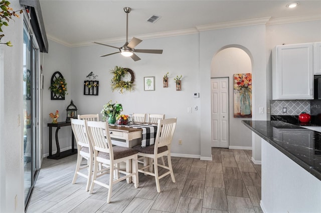 dining area with ceiling fan and crown molding