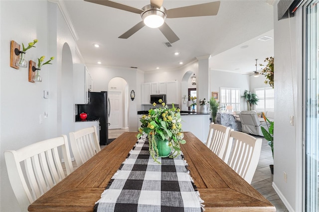 tiled dining area with crown molding and ceiling fan