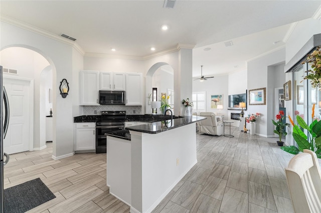 kitchen featuring ceiling fan, stainless steel appliances, white cabinets, tasteful backsplash, and crown molding