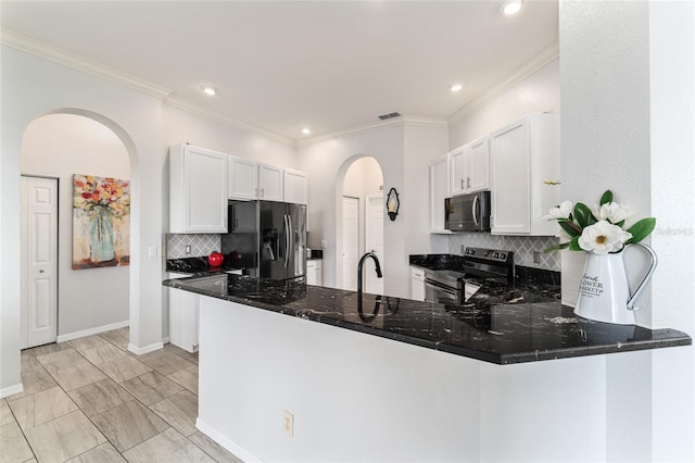 kitchen with white cabinets, tasteful backsplash, kitchen peninsula, and appliances with stainless steel finishes