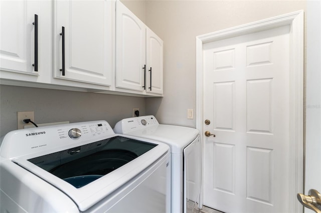 clothes washing area with cabinets, hookup for an electric dryer, and separate washer and dryer