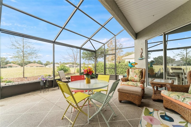 sunroom featuring vaulted ceiling with beams