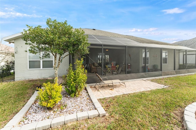 back of property with a lanai, a yard, and a patio