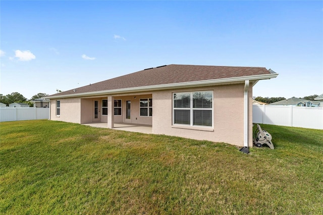 back of house with a lawn and a patio