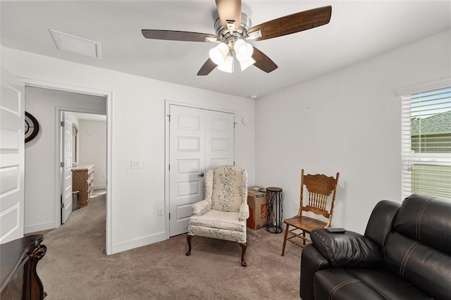 sitting room featuring dark colored carpet and ceiling fan