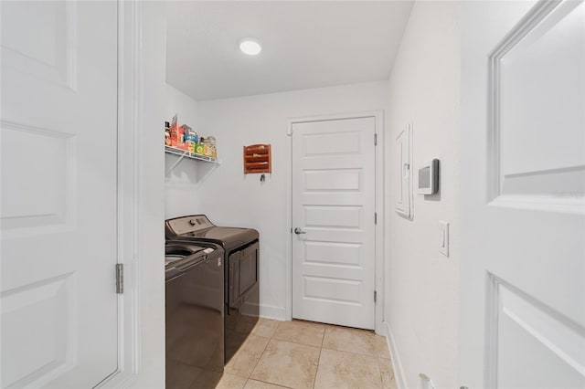 laundry area featuring washer and dryer and light tile floors