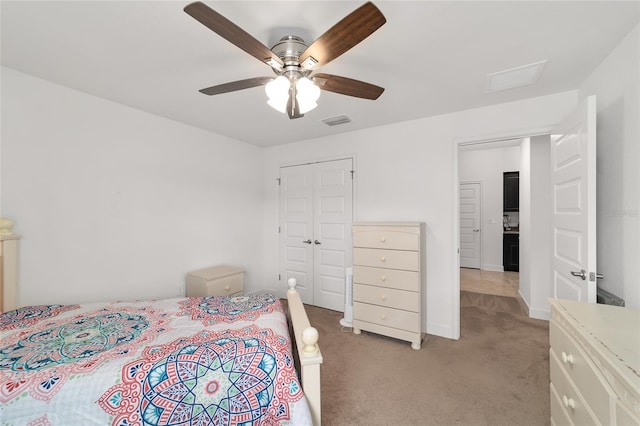 bedroom featuring a closet, light colored carpet, and ceiling fan