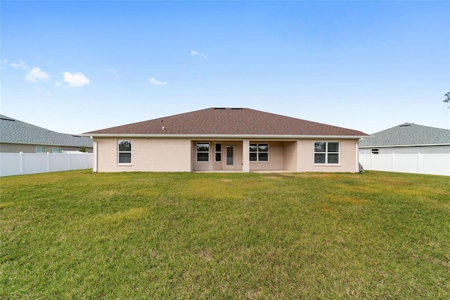 rear view of property featuring a lawn