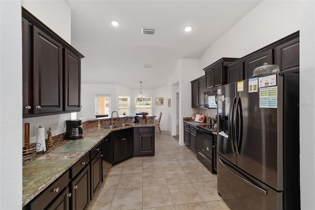 kitchen featuring stainless steel fridge, light tile flooring, black range with electric cooktop, stone counters, and a notable chandelier