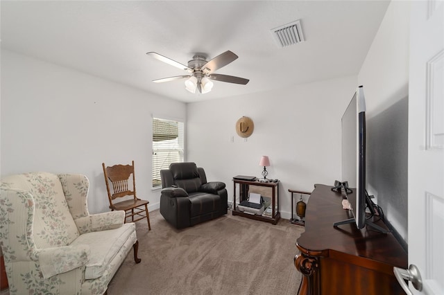 living area with light carpet and ceiling fan