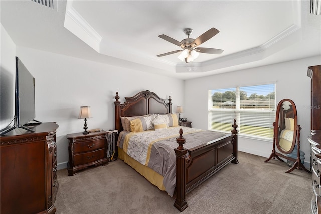 carpeted bedroom with ceiling fan, a raised ceiling, and ornamental molding