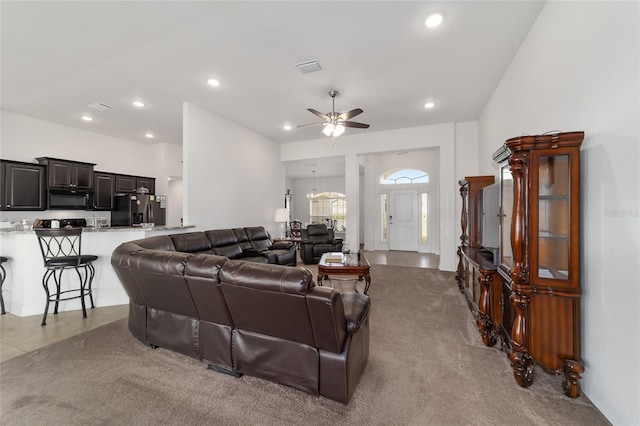 living room with light tile floors and ceiling fan with notable chandelier