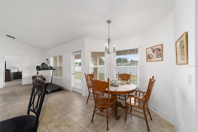 carpeted dining room with lofted ceiling, plenty of natural light, and an inviting chandelier